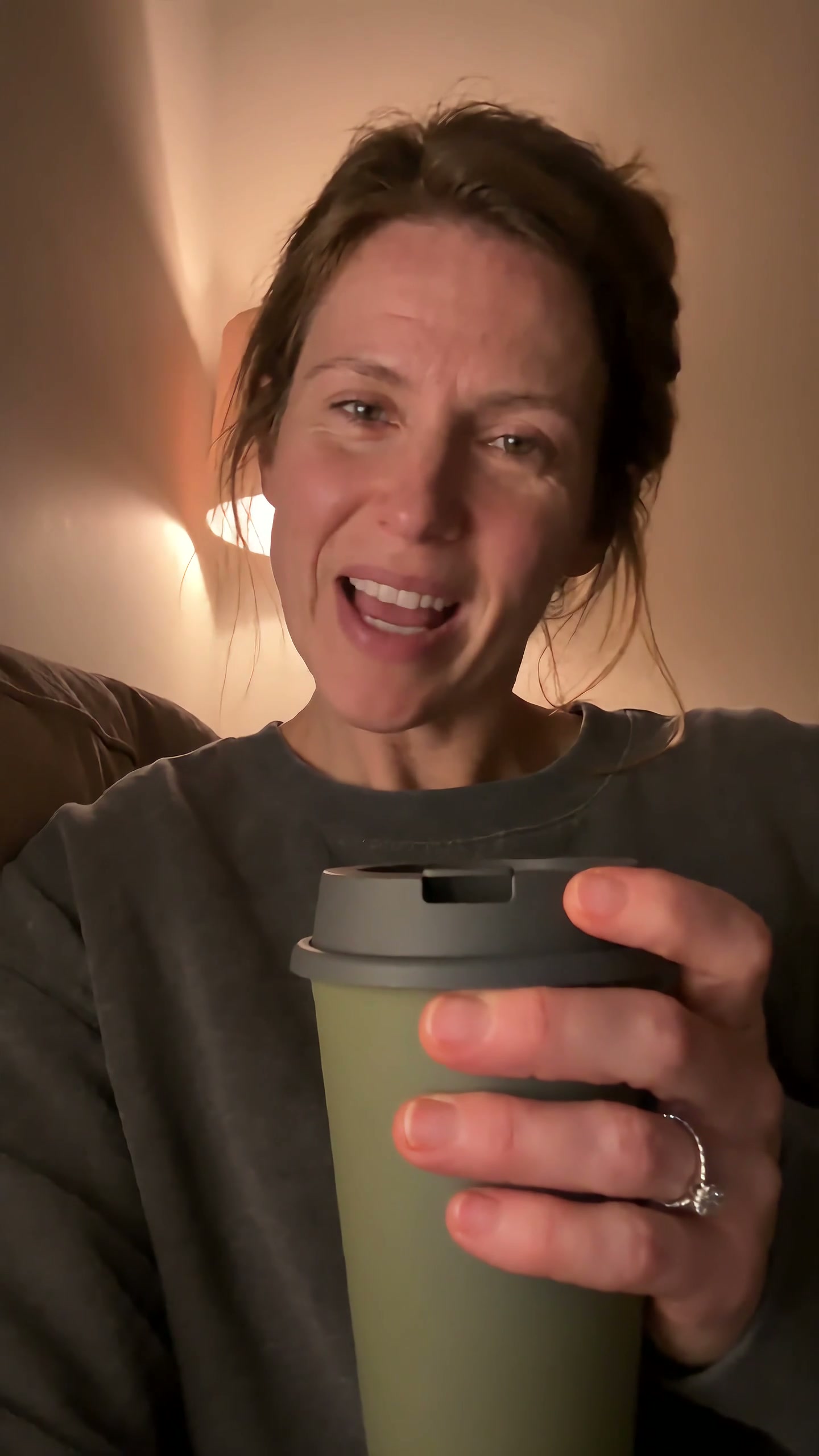 Creator smiling in warm evening light while holding the olive cup.